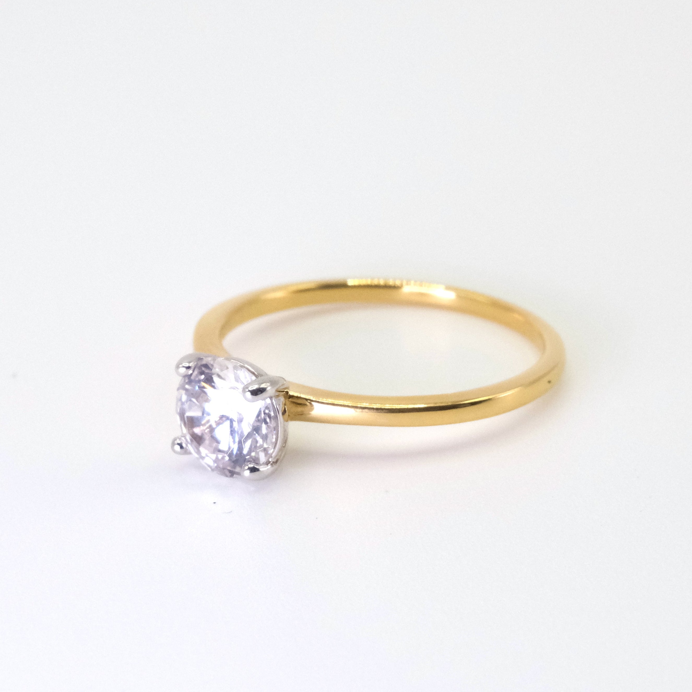 Gold ring with a diamond on a white background